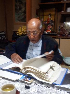 写真:岡本さんが昔の書類を見る様子