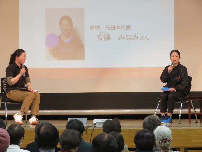 左手に司会者、右手に安藤みなみさんが座り、観客の前でトークをしている写真