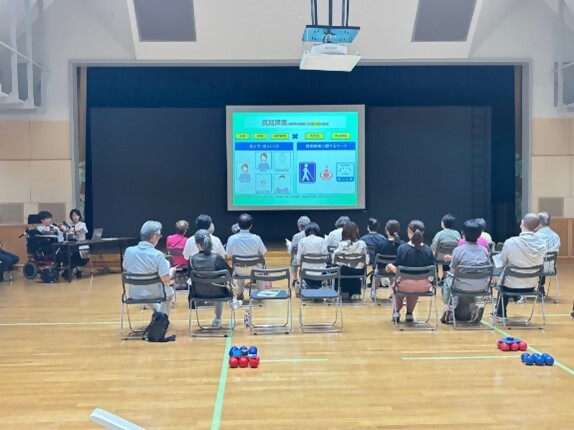 講堂で市民の方に緒方駿介さんが障害について説明している写真