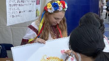 写真：避難民スタッフが市民と交流している様子