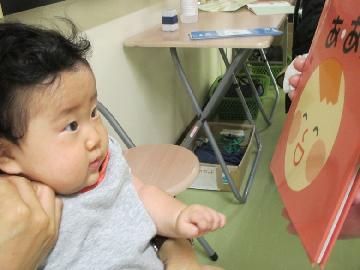 写真:絵本を見る赤ちゃん