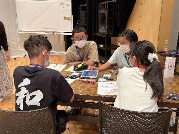 写真：タブレットを見て話し合う子どもたち