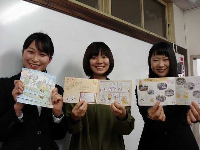 写真:地域活動紹介冊子と大学生の皆さん