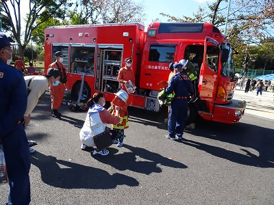 写真:八社学区コミセンまつりにて子ども防火衣を試着している様子です。2022年10月29日