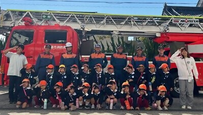 写真:はしご車の前で全員で敬礼をしています。令和5年10月25日