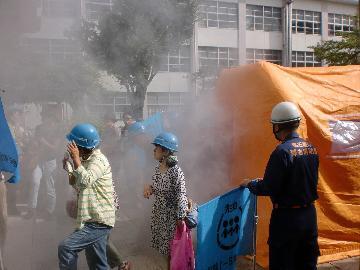 写真:テント内に無害の煙を充満させ、火災時の濃煙状況を体験しています