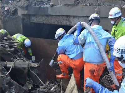 土砂災害現場に水を送り土砂を除去する写真