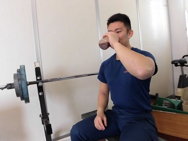 写真:トレーニングルームでプロテインを飲む消防官
