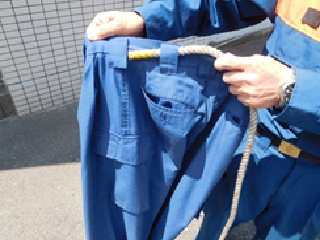 写真:背中側のベルト通しから2本のヒモを左右それぞれに通します