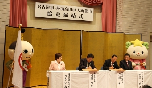 写真：両市長による協定書への署名の様子