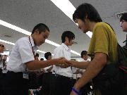 写真:手作りのアルバムを中学生に手渡すTJG311の大学生の皆さま