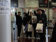 写真:笑顔で手を振りながらセントレアの出発ゲートをくぐる中学生たち