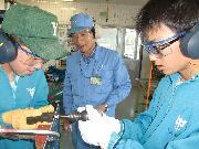 写真:三菱重工業株式会社名古屋航空宇宙システム製作所でリベット打ちに挑戦する中学生