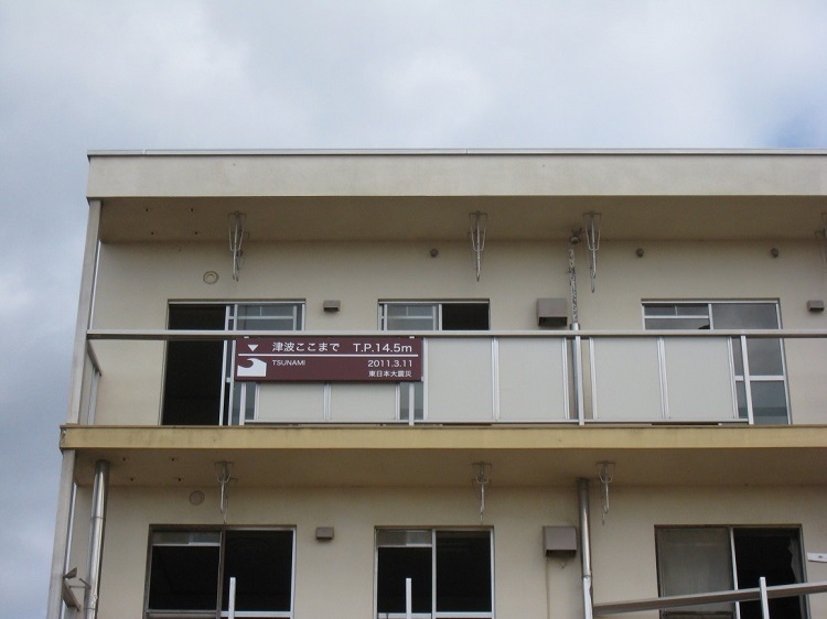 写真：津波の到達点を示す看板。T.P.14.5mまで津波が到達している。