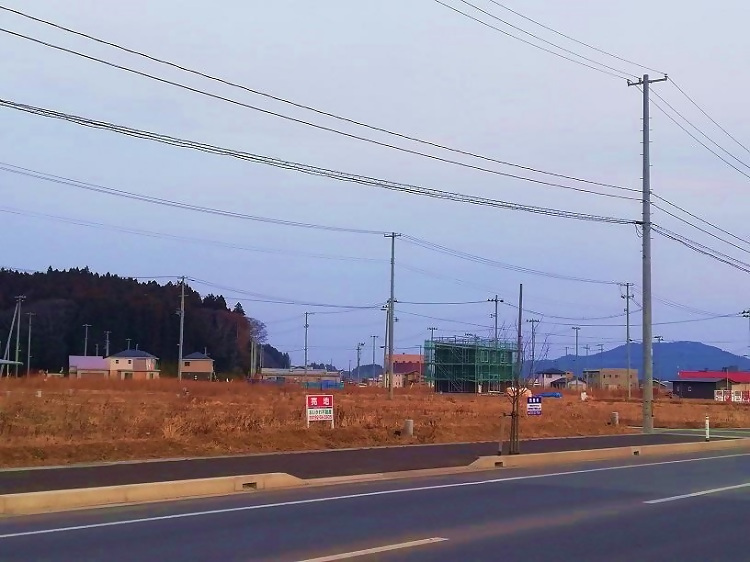 写真：高田地区の様子。売地看板が建っている。