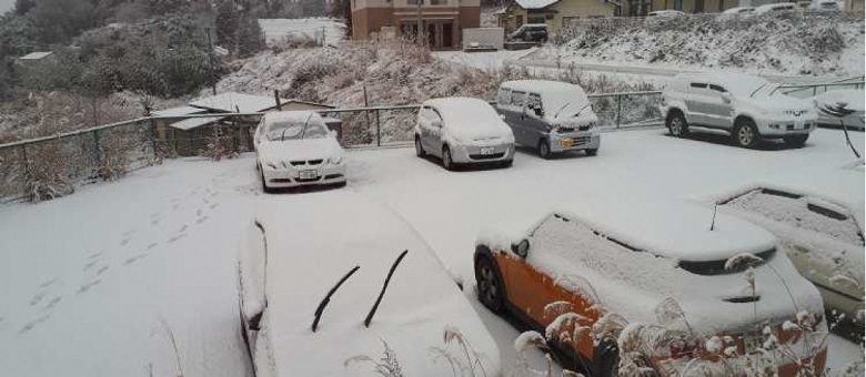 写真:一面雪が積もっている。車の上にも雪が積もっている。