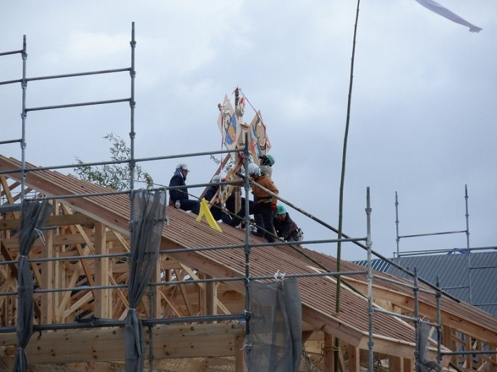 写真:矢車を取り付ける写真。複数人で作業している。