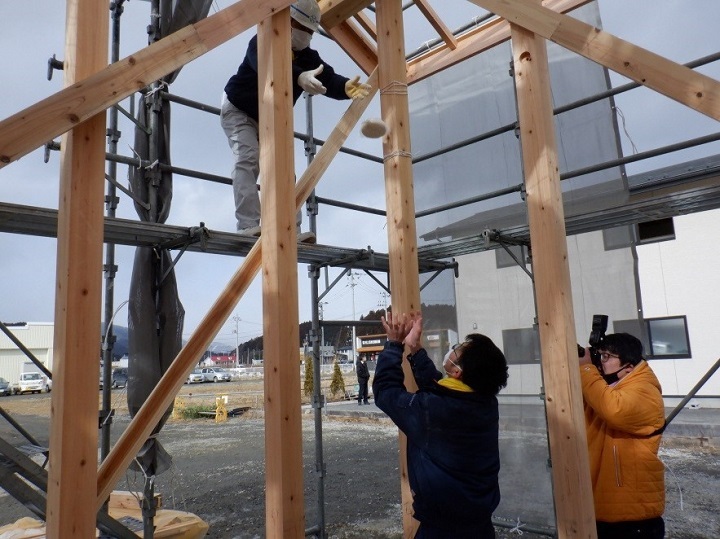 写真:隅餅を行っている写真。上から持ちを投げている。