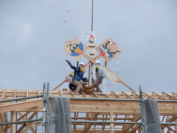 写真:餅撒き。屋上から餅を撒いている。