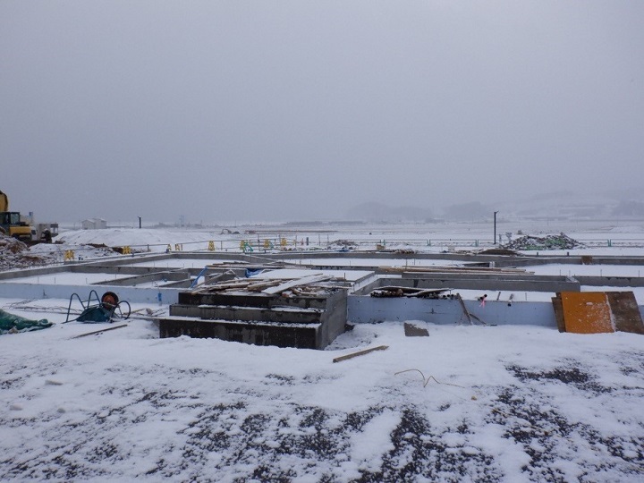 写真:工事現場。雪が全体的に積もっている。