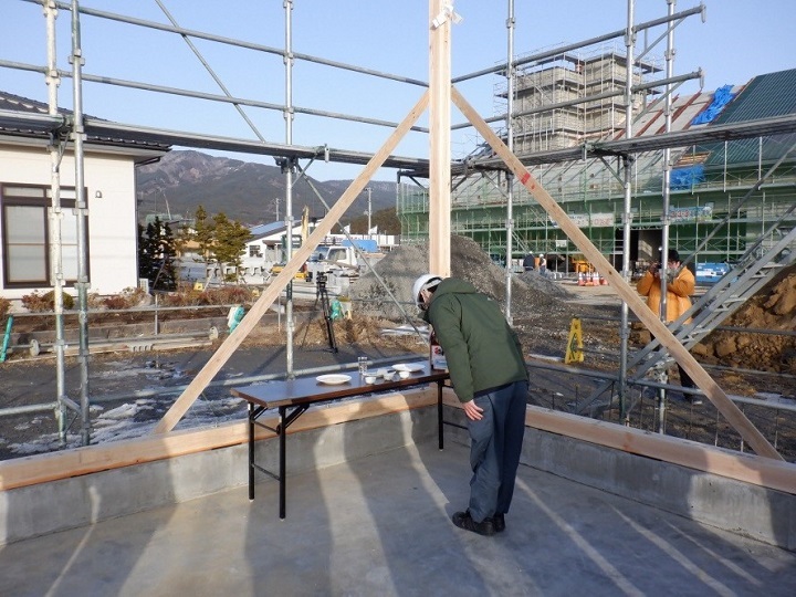 写真:工事関係者による祈願。お辞儀している。