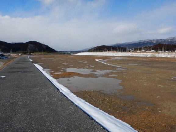 写真:平地部。景色が開けており、奥には山が見える。