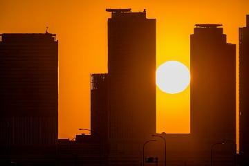 庄内川堤防から望む朝日と名古屋駅高層ビル群の写真