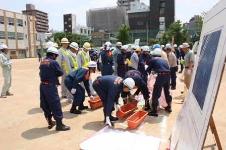 写真:簡易水防工法の訓練状況(プランターとレジャーシートによる工法)