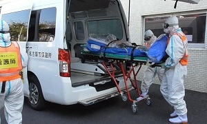 患者を移送車に乗せる様子の写真