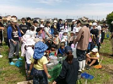 写真:草取りのあとの1回目の生きもの観察会で話を聞いている様子