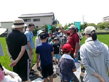 写真:生き物の先生の周りに参加者の皆さんが集まり熱心に話を聞いている様子