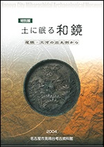 鏡が配置された表紙の写真です。蓬莱紋様とよばれる図柄の鏡です。松竹梅と鶴に亀がデザインされた鏡です。