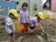 友達と裸足になってどろんこ遊びをしている写真