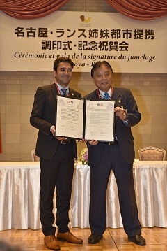 写真：協定書を掲げるランス市長と名古屋市長