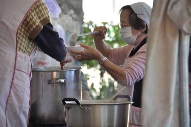 写真:もちつき大会でもちをふるまっている様子