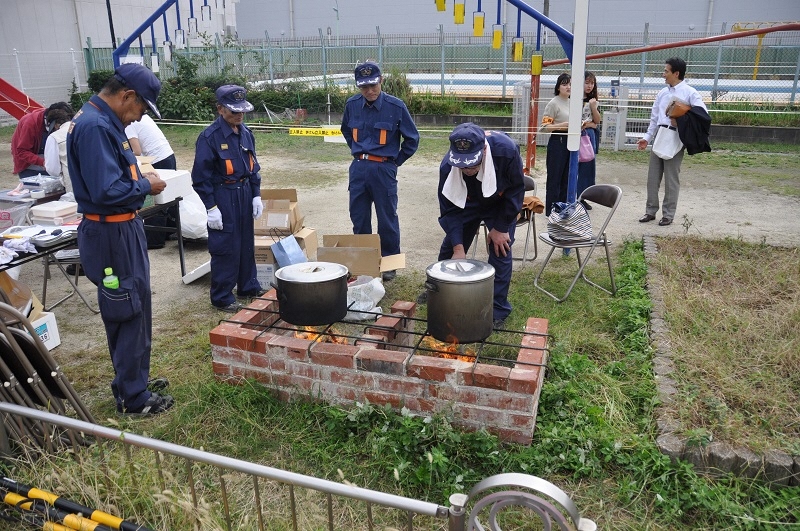 写真:かまどで食材を温めている様子