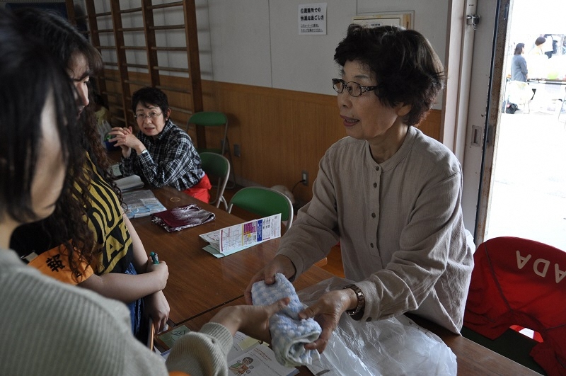 写真:女性が防災グッズについて教えている様子