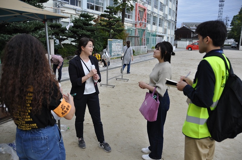 写真:学生がブースの担当者を取材している様子