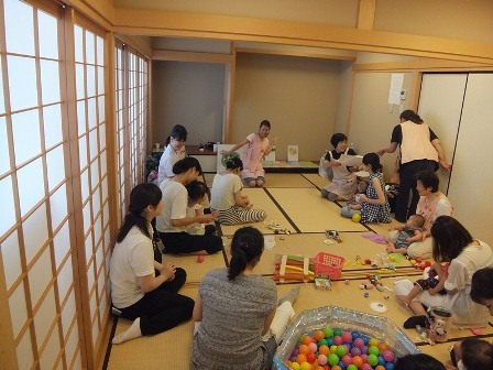 子育てサロンで、保育士さんが手遊びを教えている写真