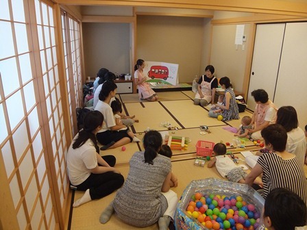 子育てサロンで、保育士さんが紙芝居を読んでくれている写真