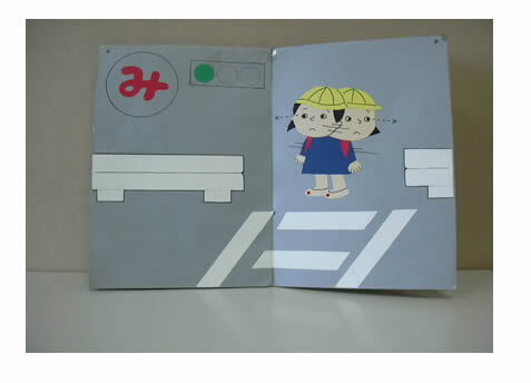 写真：横断歩道手前で左右の安全確認をするさとみちゃんの絵