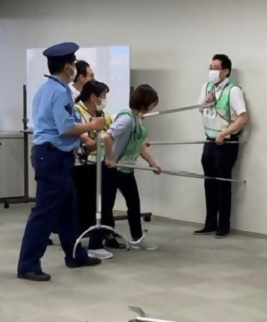 写真：「さすまた」を使って訓練をする職員たち