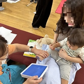 写真：足の裏にインクをつけておとなしくしている子