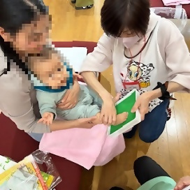 写真：おとなしく足形を取られる子