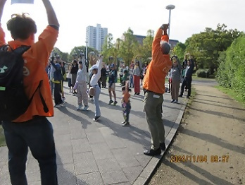 写真：参加者の皆さんと一緒に体を伸ばす職員