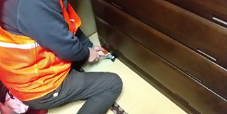 写真：タンスの下に耐震マットを入れるところ