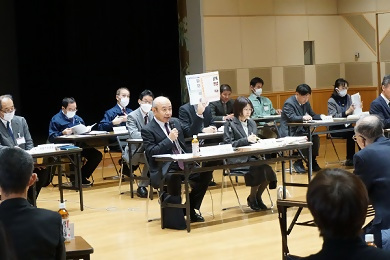 写真：区政運営方針案の説明をする伊沢教授