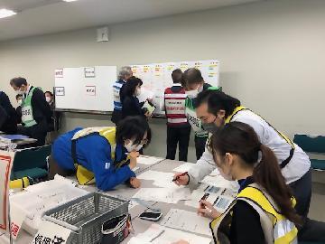 写真：ホワイトボードに書かれた各避難所の状況を把握し、支援活動を計画する様子