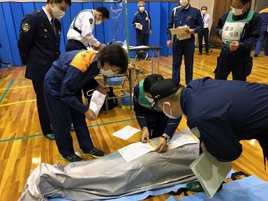 写真：納体袋に必要書類を付けている様子