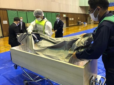 写真：ご遺体を棺に入れているところ